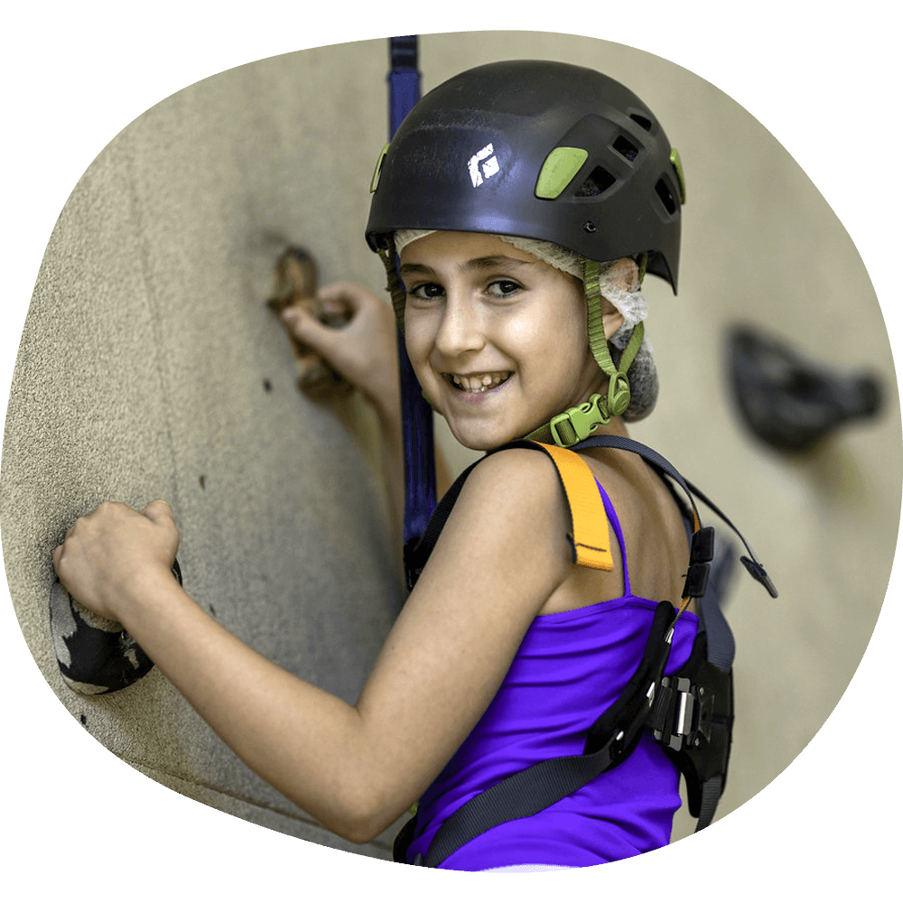 Photo of a young girl on a rock climbing wall